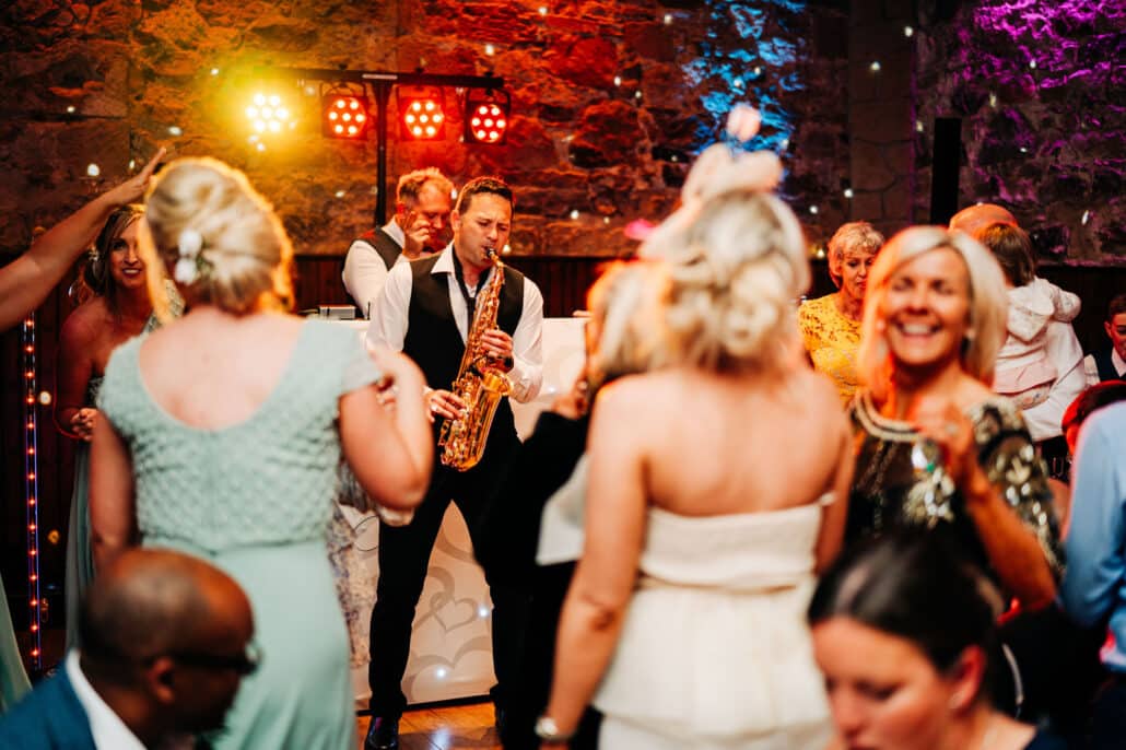 Saxophone and DJ with guests dancing at wedding