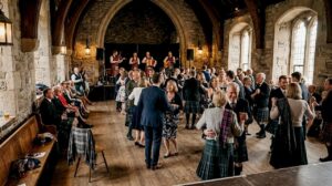 Scottish wedding guests dancing at ceilidh band