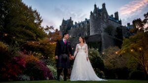 Bride and groom in front of Scottish castle